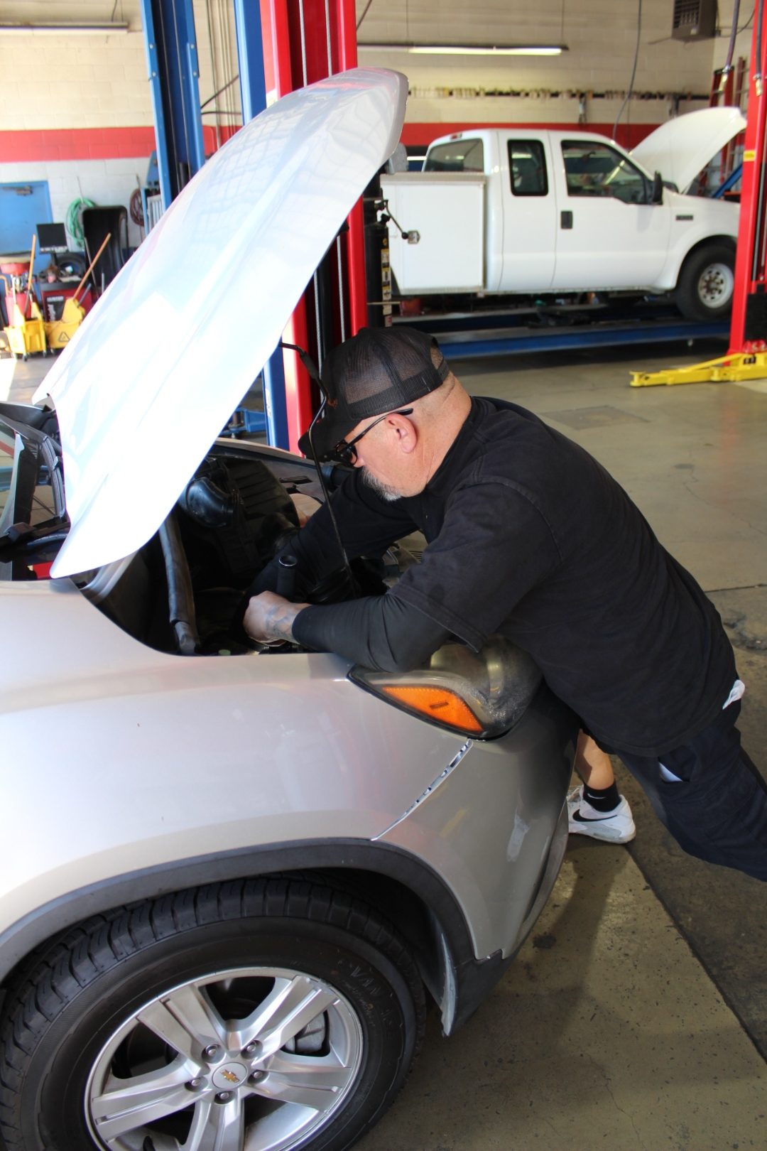 Master tech performing an engine inspection on a Chevrolet at Perry's Quality Auto