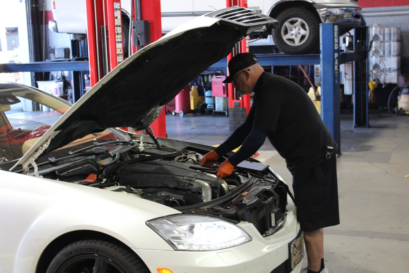 ASE Certified technician diagnosing a Mercedes-Benz engine bay at Perry's Quality Auto